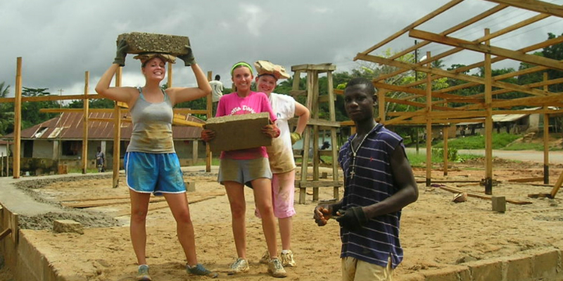 students and Ghanaian at construction site