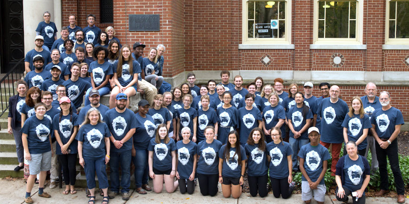  Faculty, staff and students on steps of alumni hall. All wearing tom dutton legacy tshirts