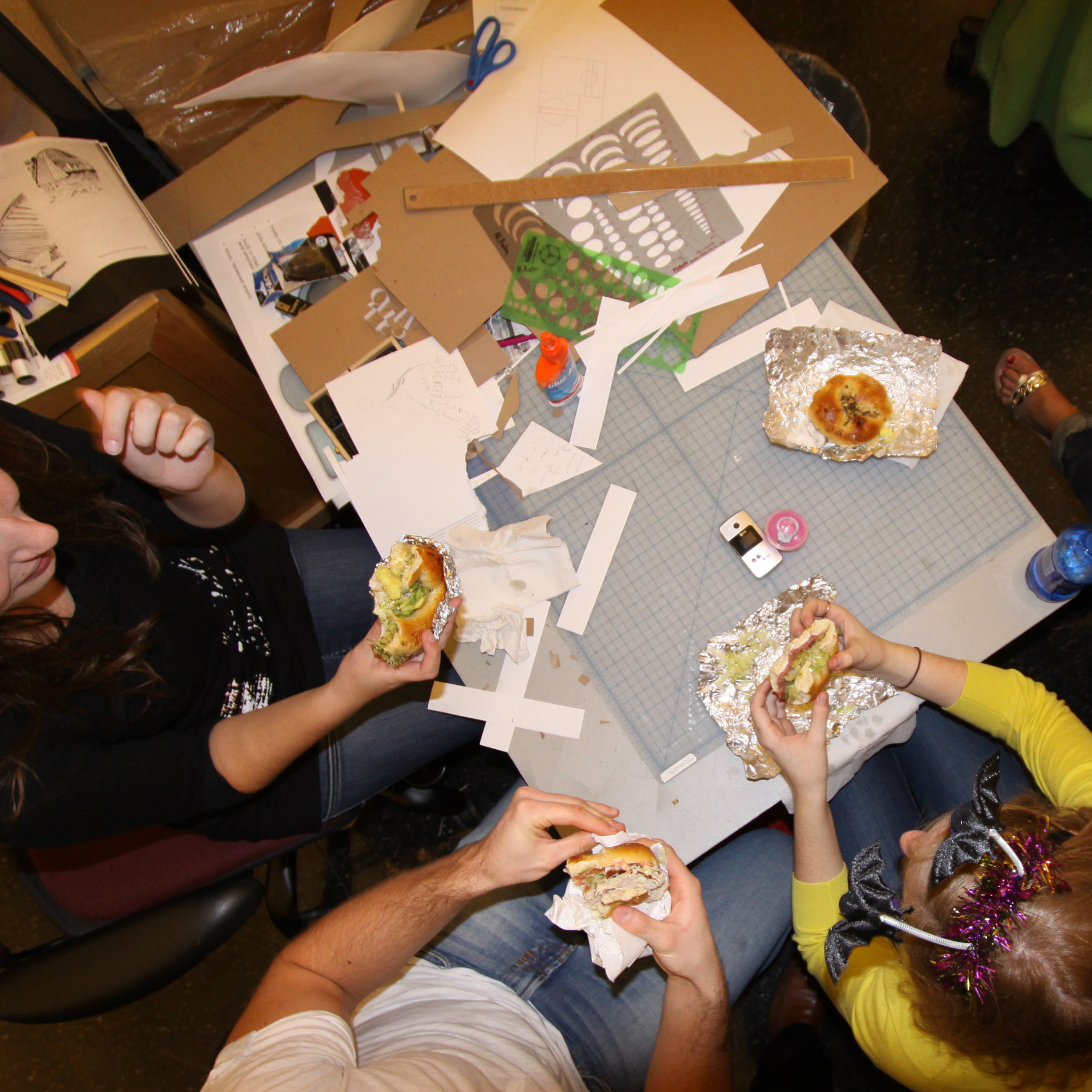 overhead view of students in studio eating bagel sandwiches