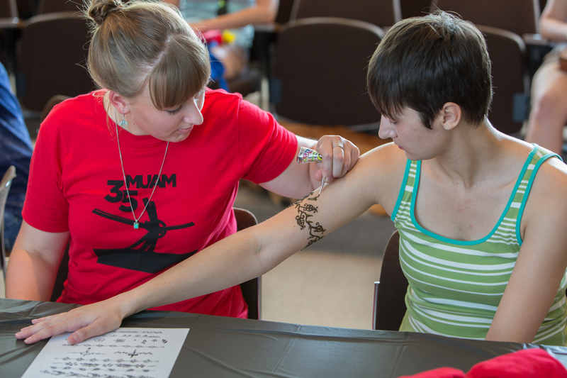  A student receives a henna tattoo on her arm