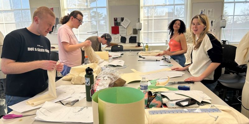 Students working at a table in the fashion design classroom