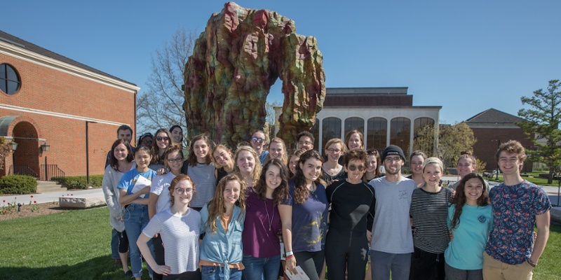  Students stand with the donor at the dedication of Hand in Heart sculpture. The fine arts plaza is visible in the background