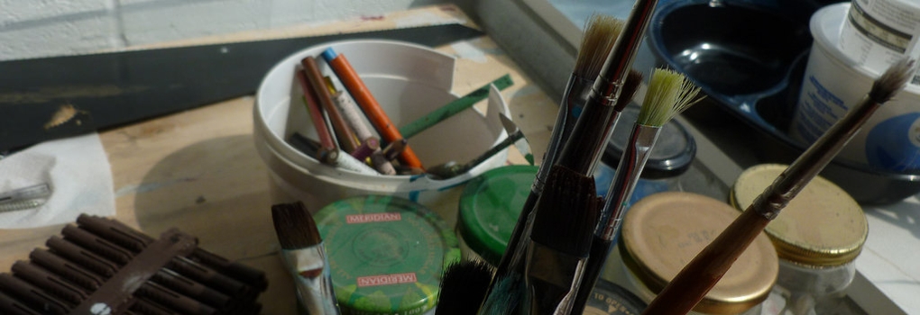 Assorted art supplies and tools on a tabletop