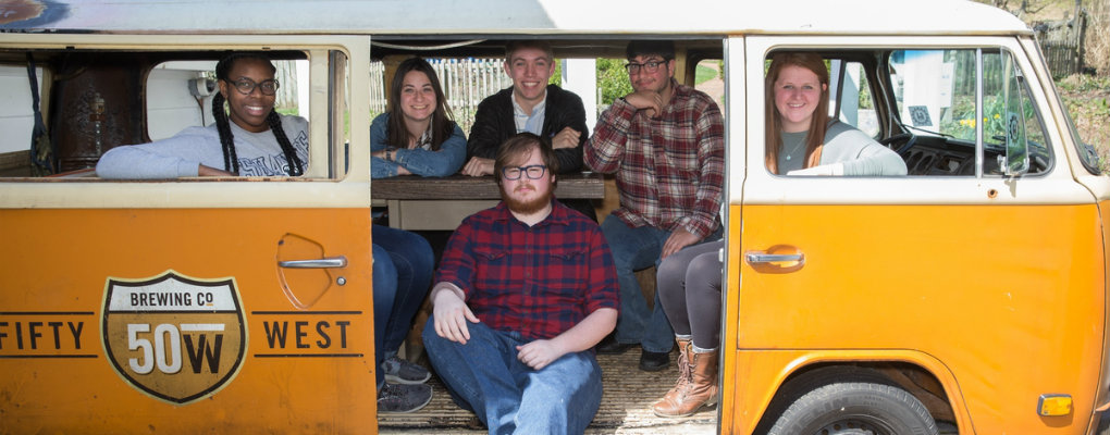 students pose for a photo inside of the fifty west brewery bus in cincinnati