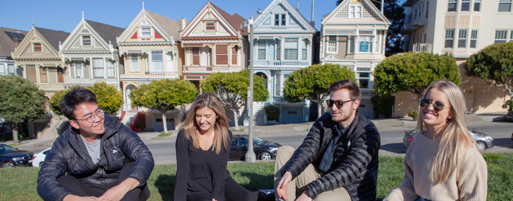 Students relax on the grass near the Painted Ladies rowhouses in San Francisco