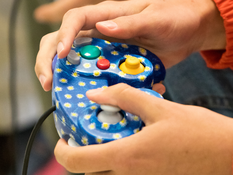 hands holding colorful game controller