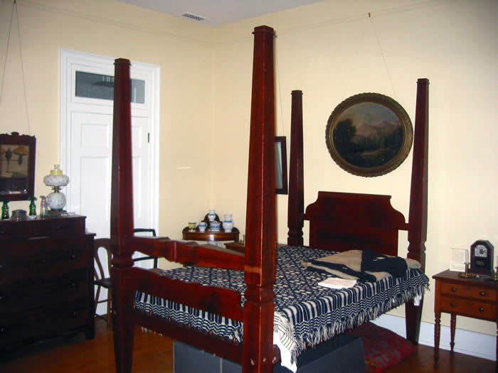 Bedroom furnished with a four-poster bed, nightstand, and dresser