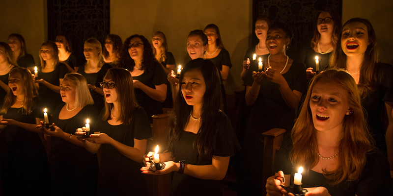 Members of the Choraliers hold candles and sing in a darkened chapel during the annual Ceremony of Carols performance, 2016 