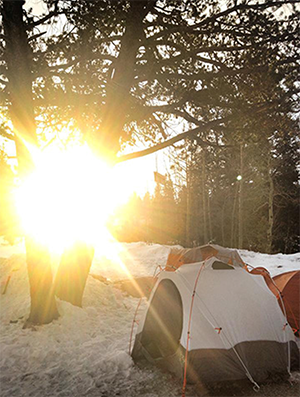 Sunrise over tents in snow in the Rockies
