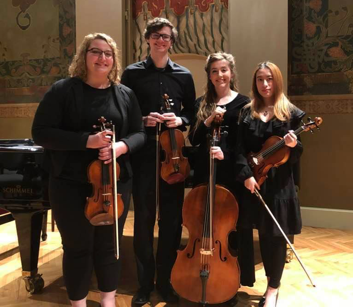 Taylor Wallace, Ben Martin, Xinyi Yan, and Natalie Rocke pose with instruments at the festival