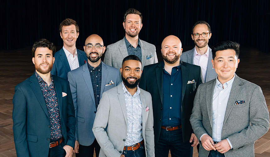 The members of Cantus a group of men wearing jeans and button shirts and jackets in calming shades of blue and grey