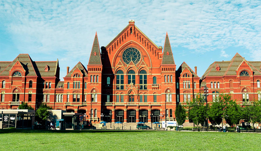 Photo of the front of Cincinnati Music Hall on a sunny day with a green lawn and bright blue sky