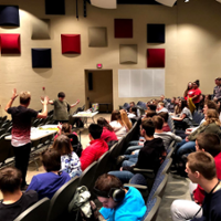 With raised arms, Kevin Spencer works with Best Buddies group at Talawanda High School