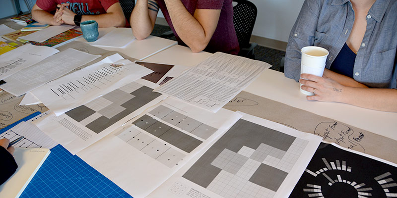 students at a table with magazine designs