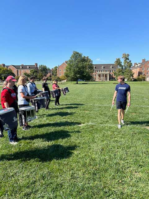 Students playing snare drums in a drumline