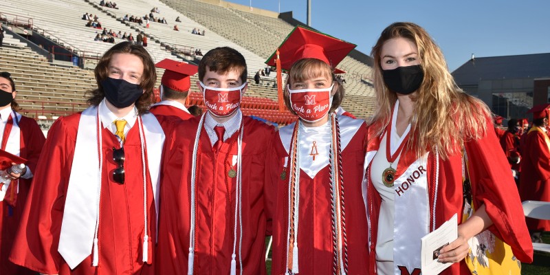 Four honors students wearing masks before the graduation ceremony