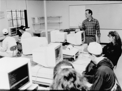 Black and white photo of a professor teaching students in a computer lab