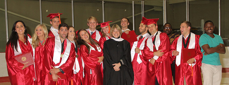 Group picture of cohort 1 in graduation caps and gowns at Goggin