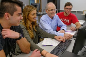 Dr. Kiper working with students on a computer