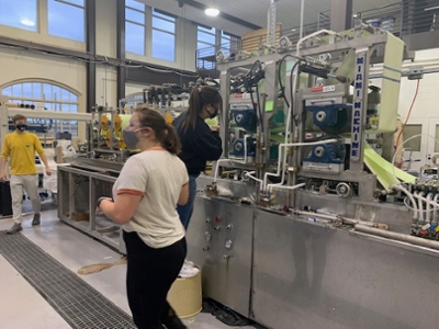 Three students working on the paper machine