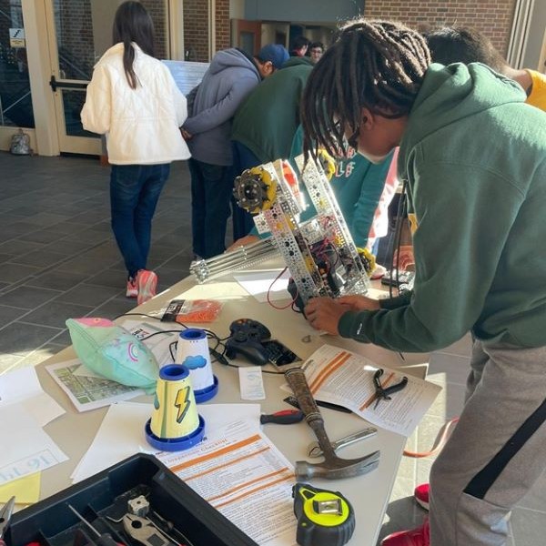 Male student working on a tech project at a table