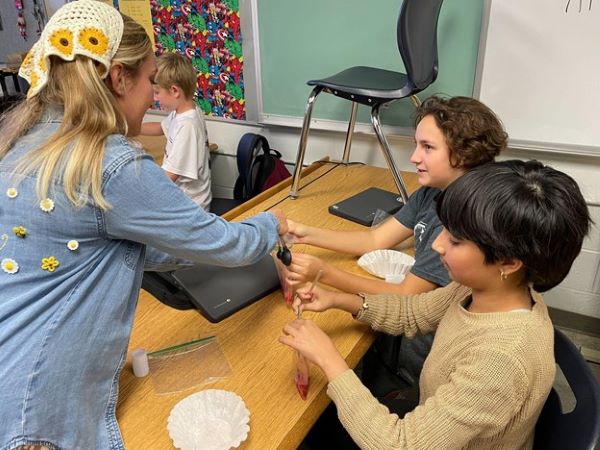 Female teacher working with two students.