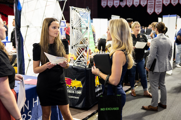 student talking to a recruiter at career fair.