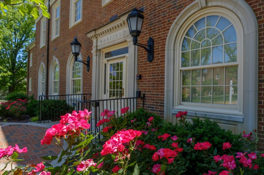 Front of Warfield Hall with pick flowers.