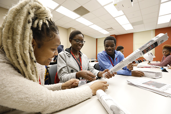 Two students sit at a table with a staff mentor.