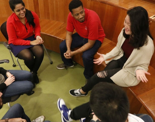 Students seated in a circle engaged in discussion