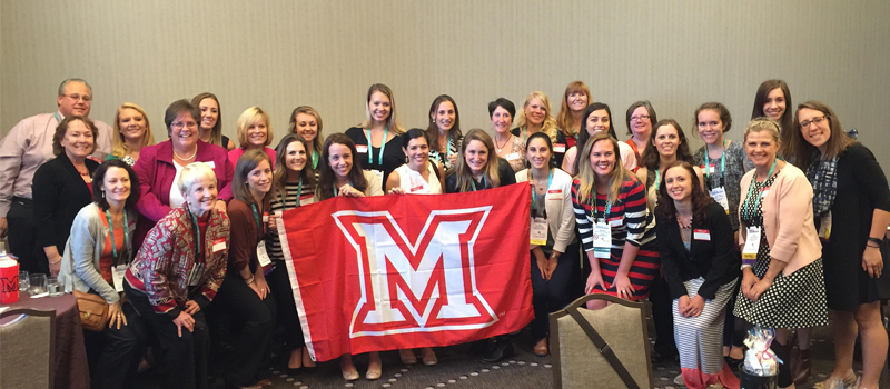 group of nutrition students taking a photo with the Miami flag