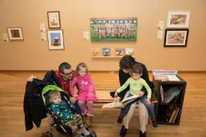 family sits in art exhibit