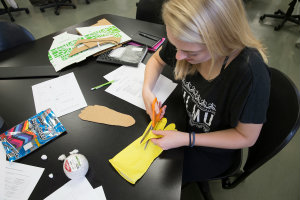 girl uses scissors to cut rubber glove