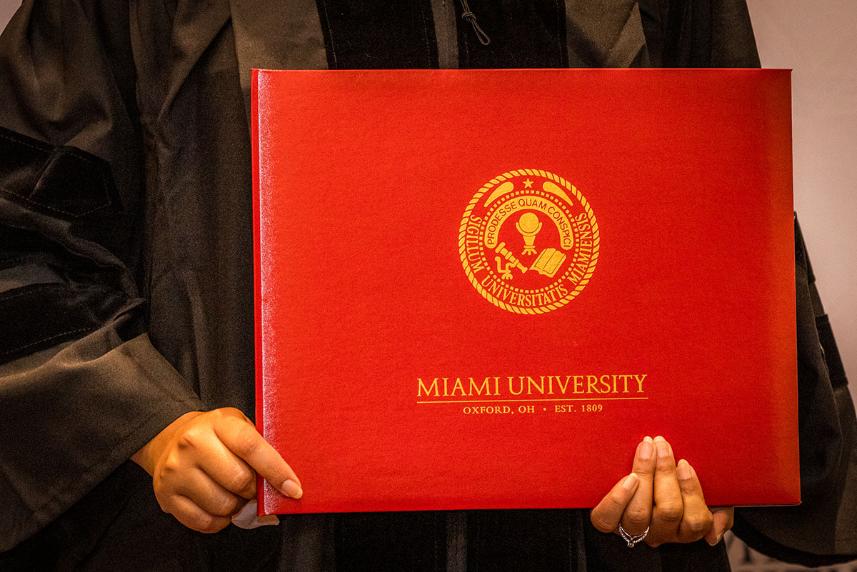 Student holding graduate degree folio