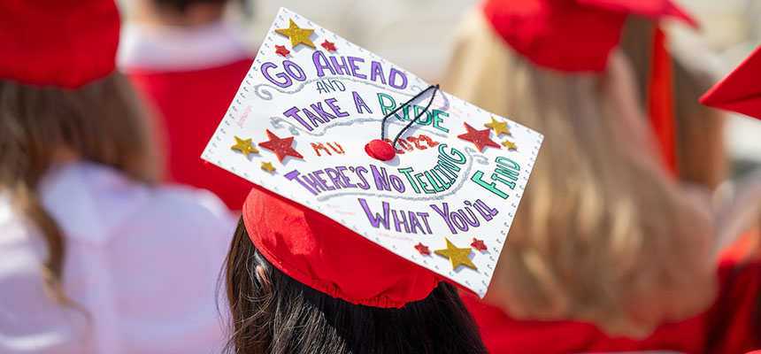  A Miami graduate with a cap reading "Go Ahead and Take a Ride There's No Telling What You'll Find."