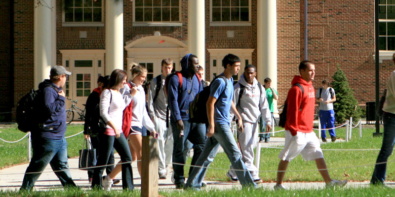 Group of students walking with backpacks outside of the Farmer School of Business