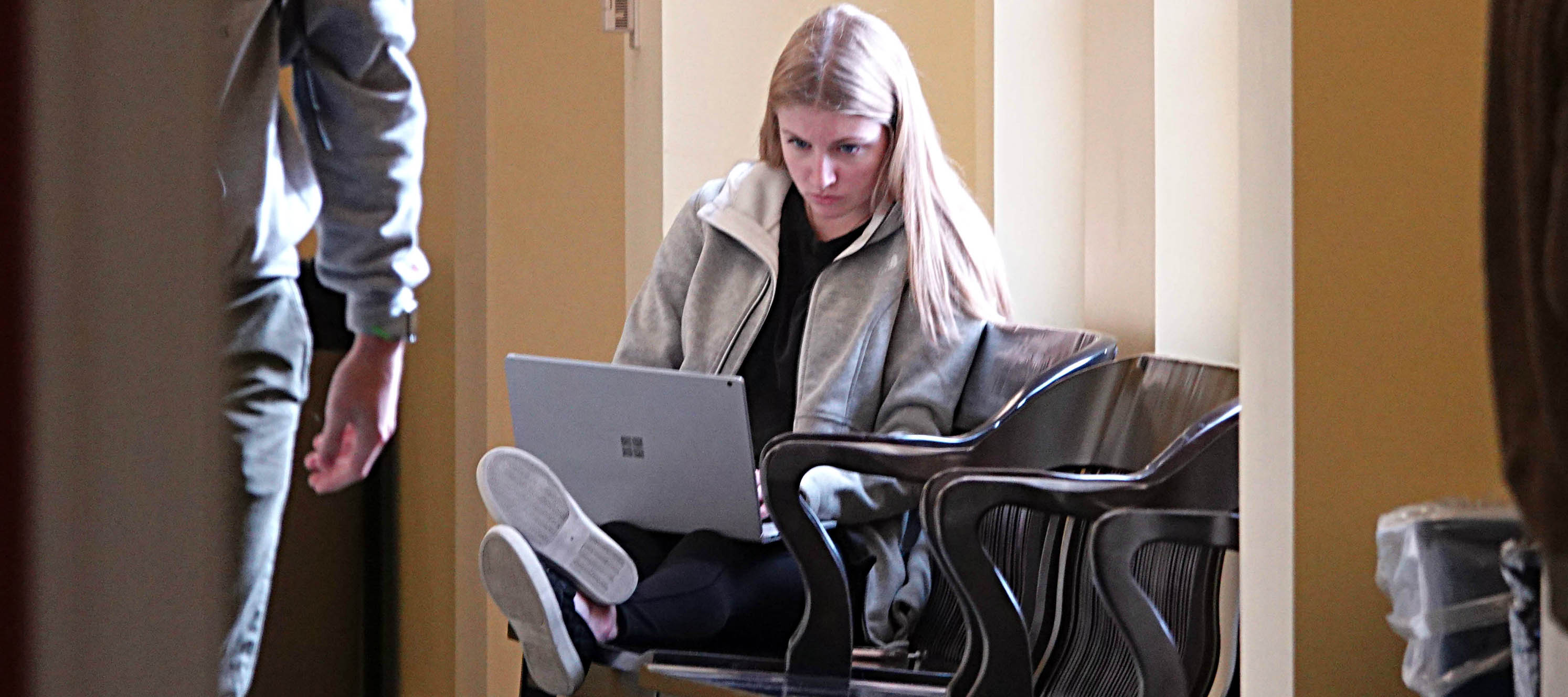  Student using laptop on hallway bench