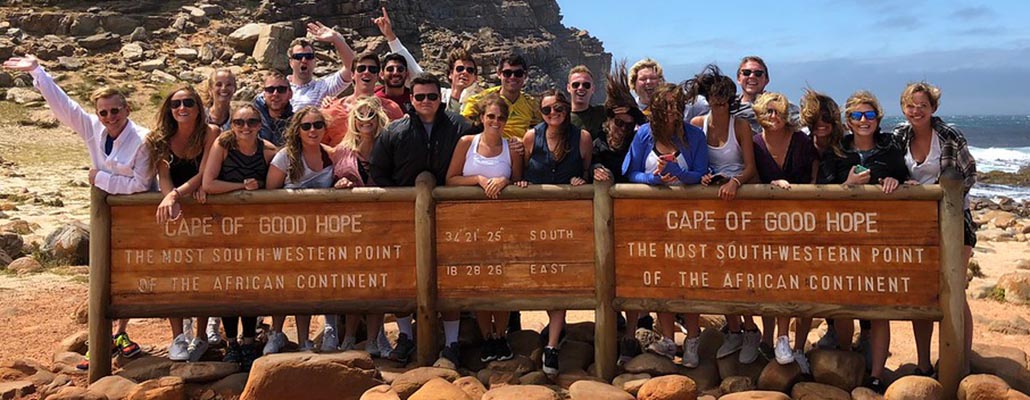  Students pose by sign at Cape of Good Hope in South Africa