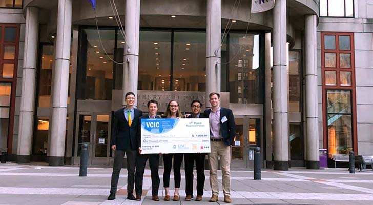 FSB group poses with oversized check outside NYU