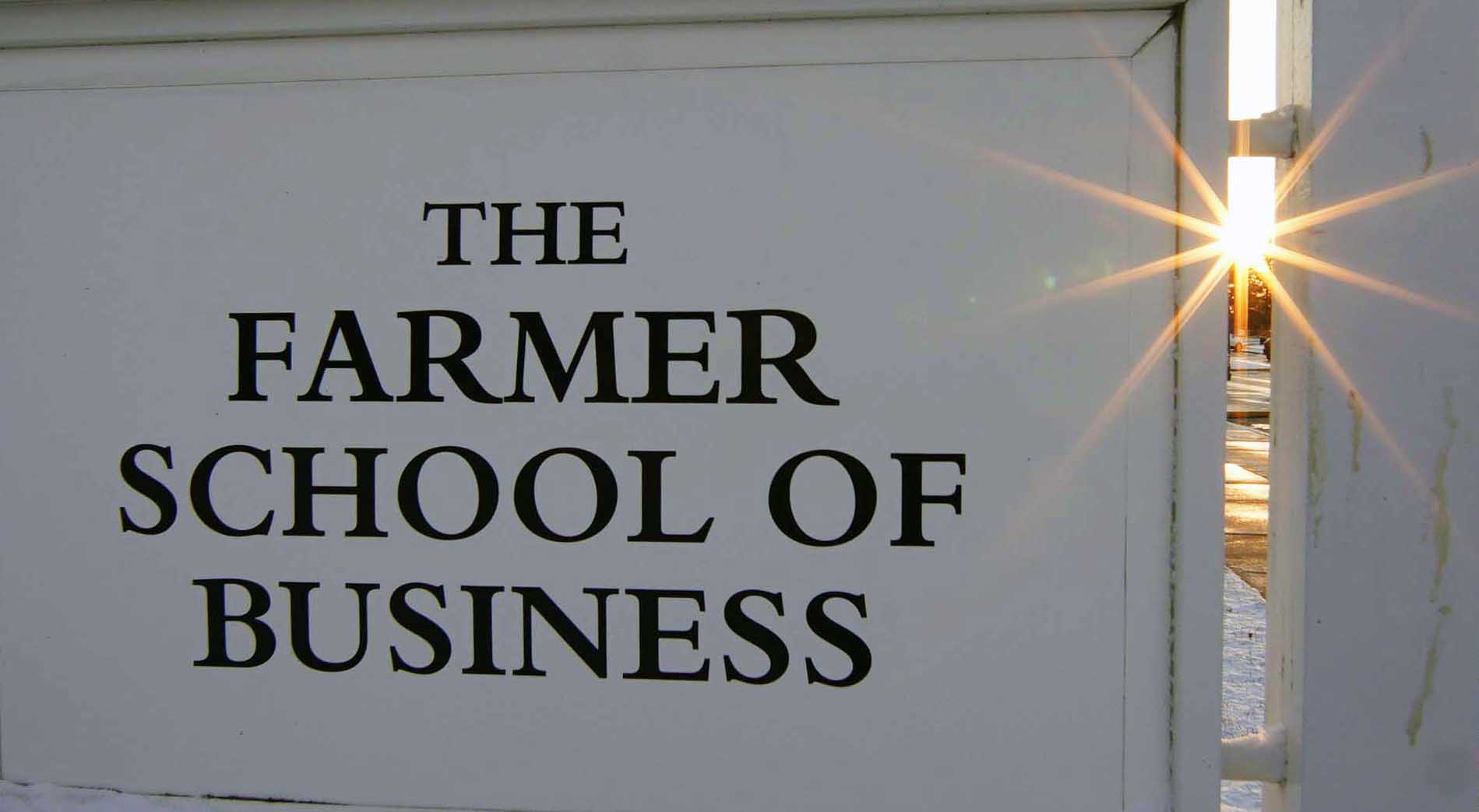 Farmer School sign with sun coming through one end