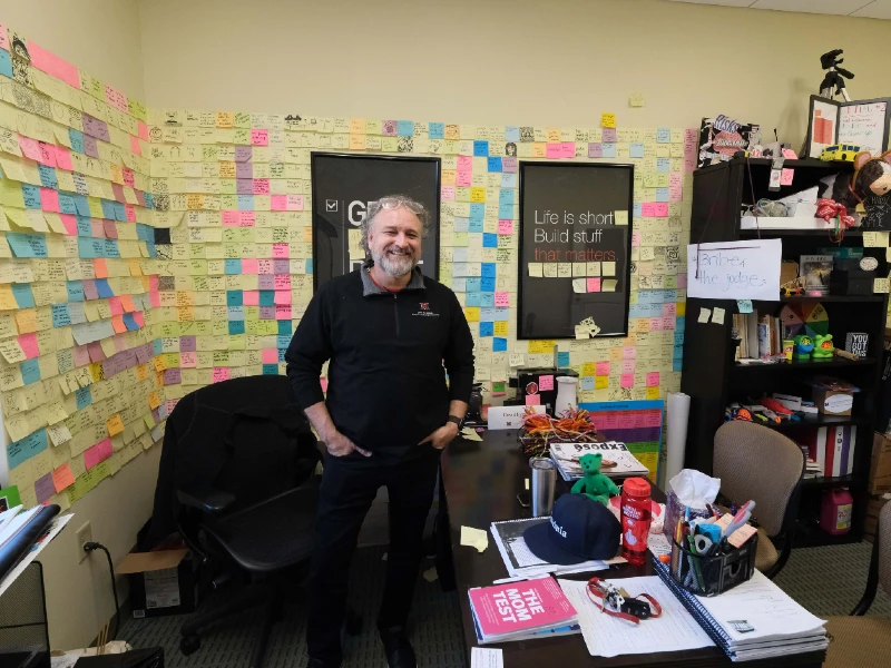 professor eyman in his office surrounding by post it notes