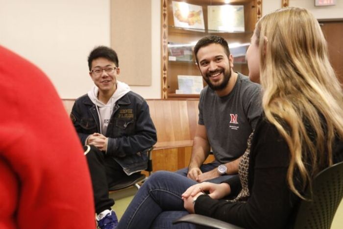 Three Miami students having a conversation with each other, smiling