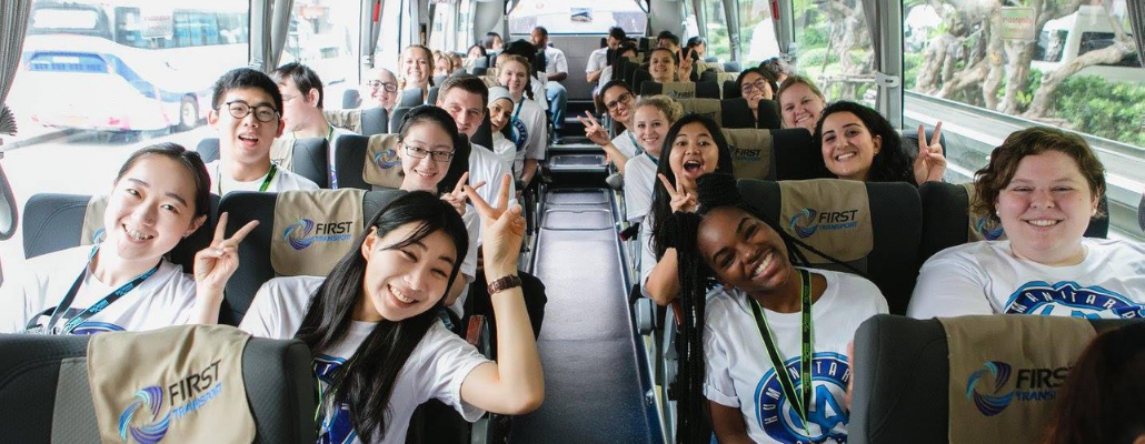  students on a bus at a past Humanitarian Leadership conference