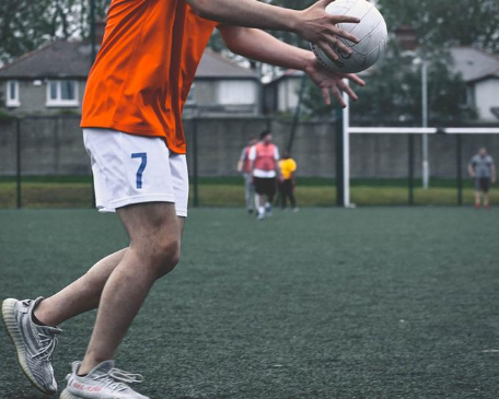 A picture of a Miami Student playing Gaelic Football in Dublin, Ireland.