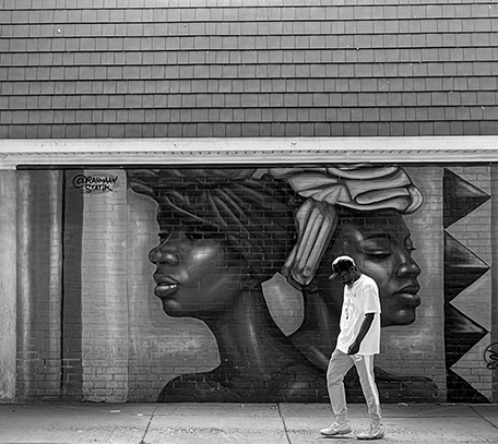A man walks by a street mural