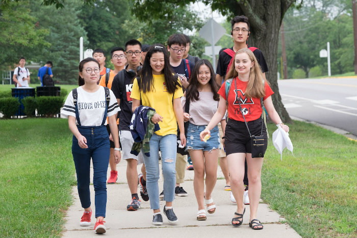 Students walking with orientation leader on campus tour