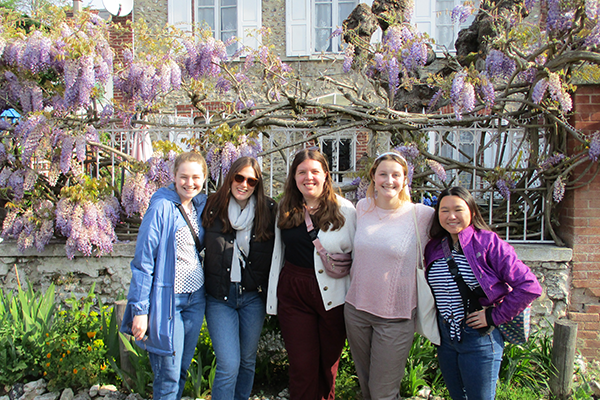 Group of students in Normandy with spring blossoms