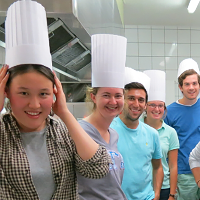 students wear chef hats in a kitchen