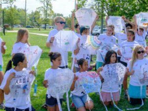 Drawing contest participants hold up their drawings for viewing.