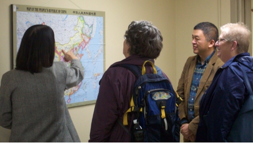 Leo Chan and Miami University staff and Mayor of Oxford looking at map of China